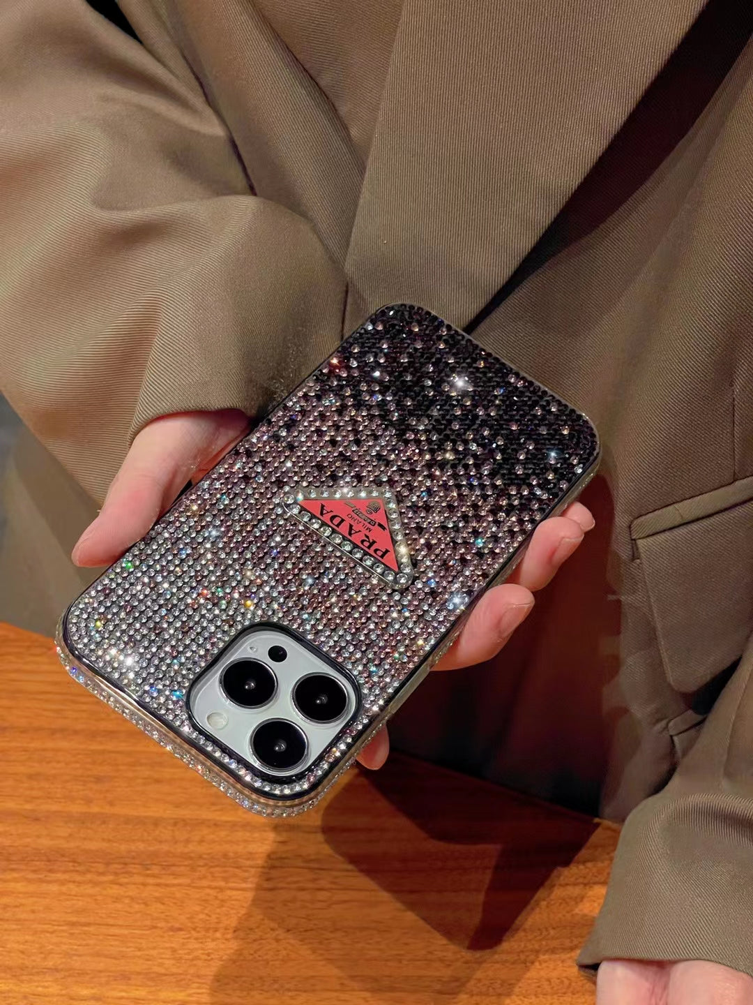 Luxury Prada Diamond iPhone Case on a marble surface.