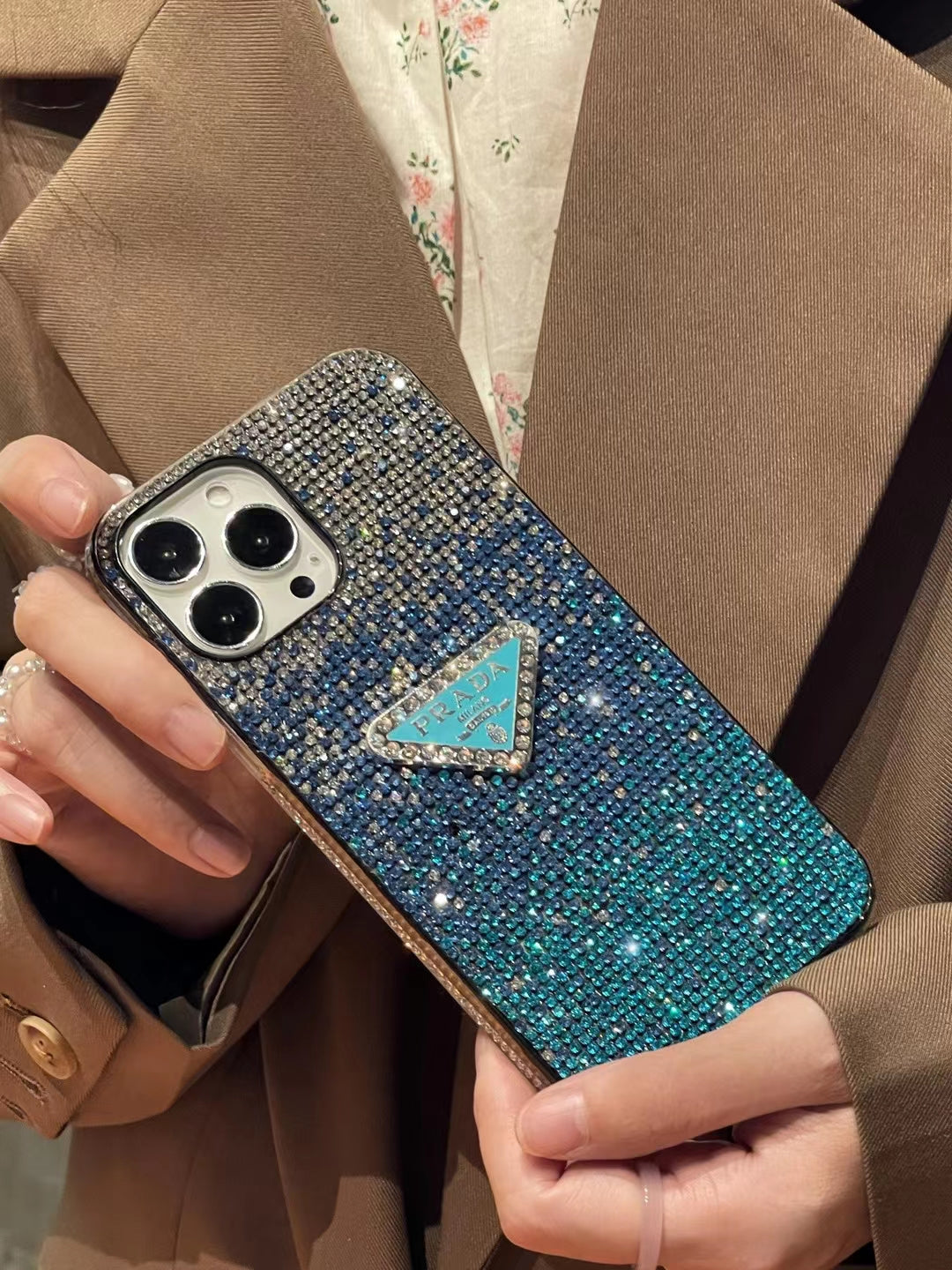iPhone in Luxury Prada Diamond Case held in a stylish hand.