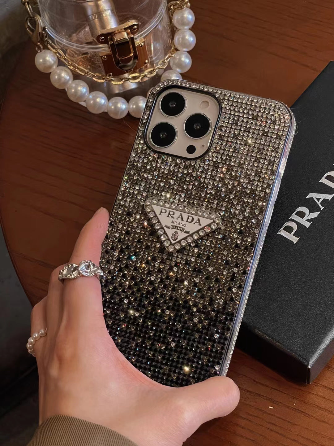 Luxury Prada Diamond iPhone Case protecting iPhone on a desk.